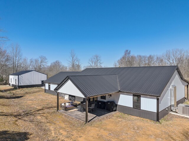 exterior space with a pole building, metal roof, and central AC unit