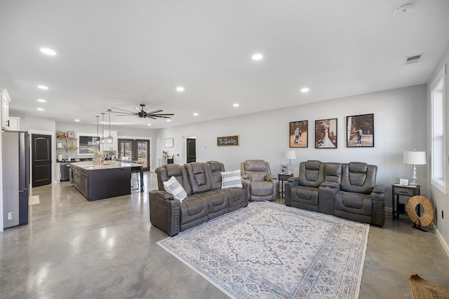 living room with finished concrete flooring, ceiling fan, a healthy amount of sunlight, and recessed lighting