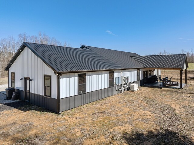 rear view of house featuring a patio area and metal roof