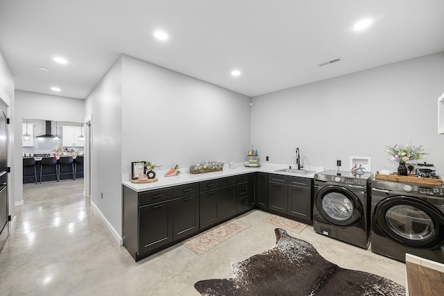 laundry area with cabinet space, separate washer and dryer, a sink, and recessed lighting