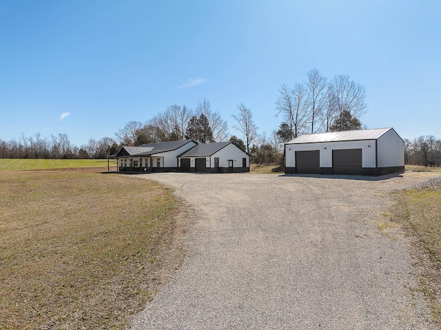 view of front of home featuring a detached garage and an outdoor structure