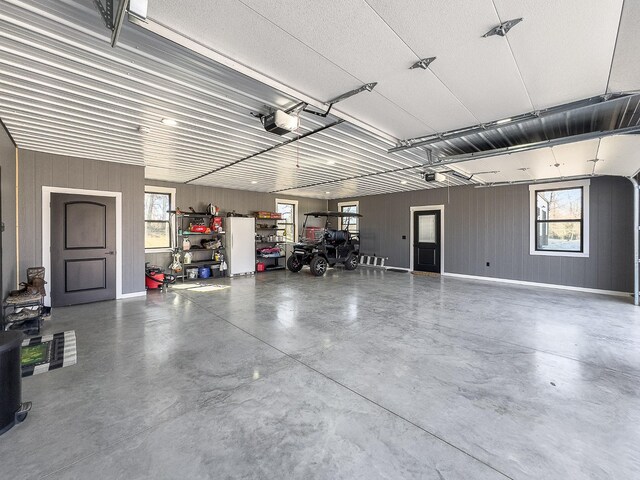 garage featuring a garage door opener and metal wall