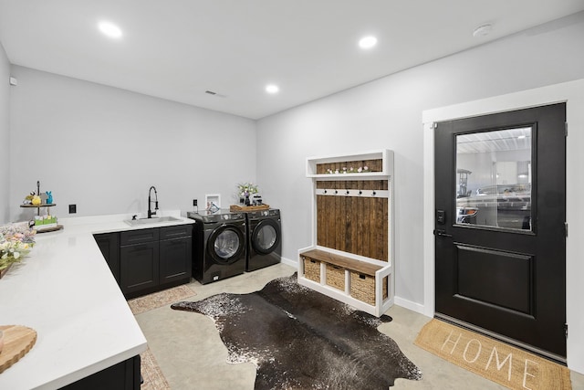 laundry room featuring recessed lighting, cabinet space, a sink, washer and dryer, and baseboards