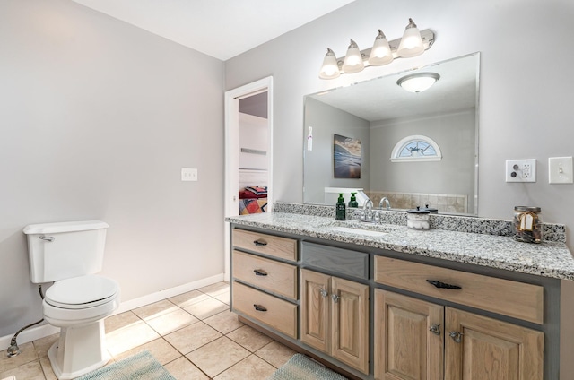 bathroom featuring tile patterned floors, toilet, vanity, and baseboards