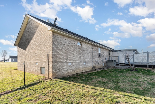 back of house featuring a yard, central air condition unit, brick siding, and a deck