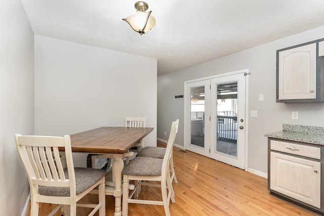 dining area featuring visible vents, baseboards, and light wood finished floors