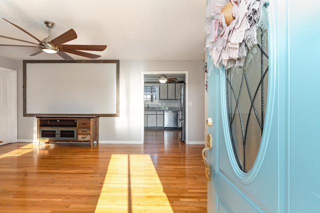 entryway featuring ceiling fan, baseboards, and wood finished floors