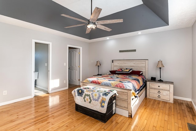 bedroom with visible vents, baseboards, light wood finished floors, recessed lighting, and a raised ceiling