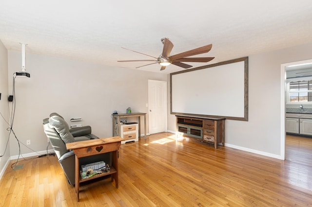 office featuring baseboards, light wood finished floors, and ceiling fan