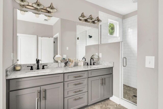 full bathroom featuring double vanity, a stall shower, a sink, and visible vents