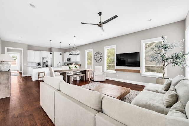 living area with dark wood-style floors, recessed lighting, ceiling fan, and baseboards