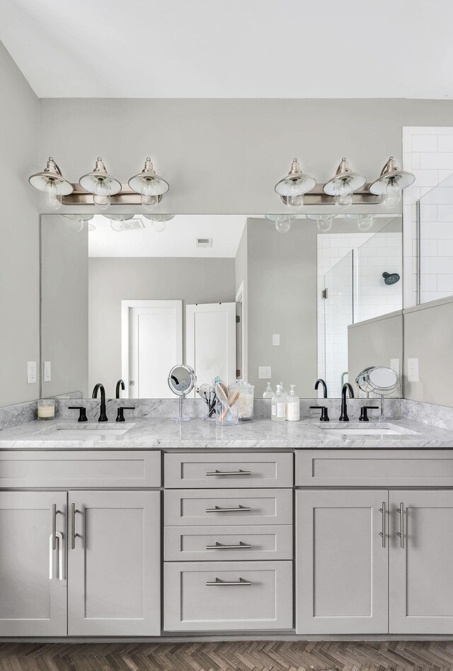 bathroom with visible vents, walk in shower, and vanity