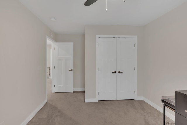 unfurnished bedroom with carpet floors, a ceiling fan, baseboards, and a closet