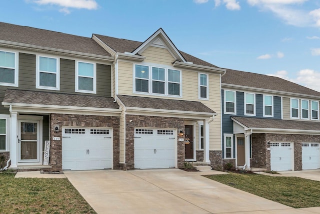 multi unit property featuring driveway, stone siding, a garage, and roof with shingles