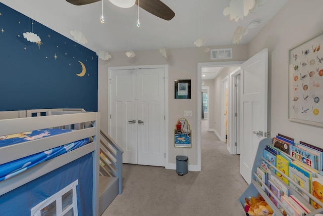 carpeted bedroom with ceiling fan, a closet, visible vents, and baseboards