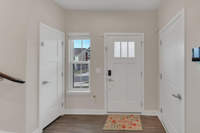 foyer featuring dark wood-type flooring and baseboards