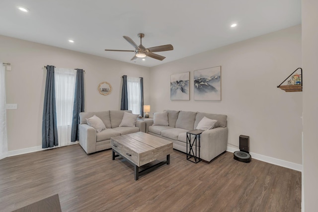 living room featuring a ceiling fan, baseboards, and wood finished floors