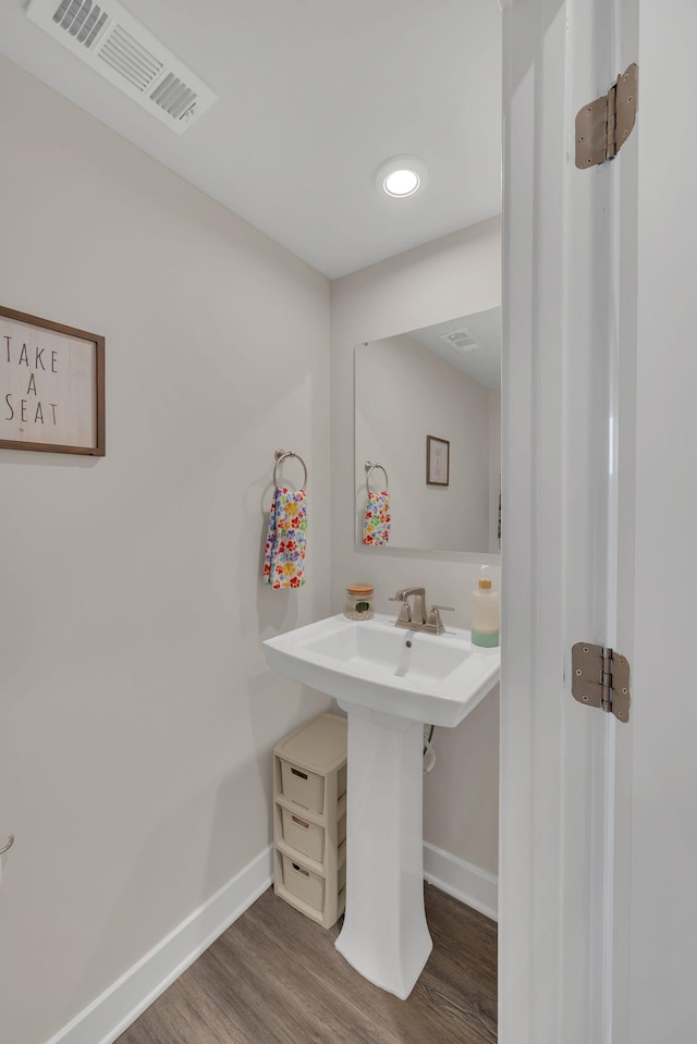 bathroom featuring baseboards, visible vents, and wood finished floors