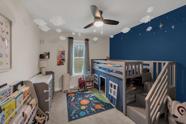 carpeted bedroom with ceiling fan and baseboards