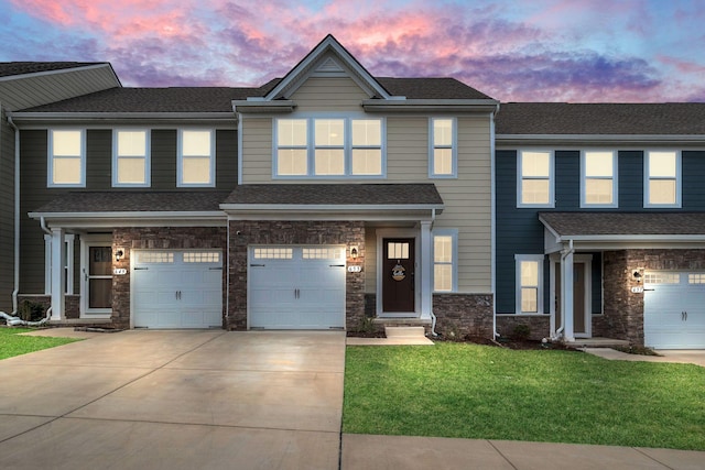 view of front of property with a garage, concrete driveway, stone siding, roof with shingles, and a front lawn