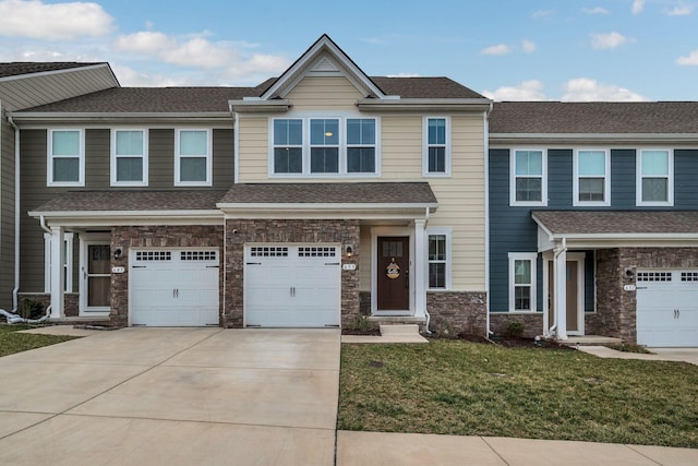 view of front of house featuring an attached garage, concrete driveway, stone siding, roof with shingles, and a front yard