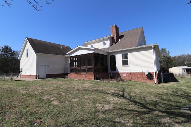 rear view of property with fence, a yard, a sunroom, a shingled roof, and a chimney