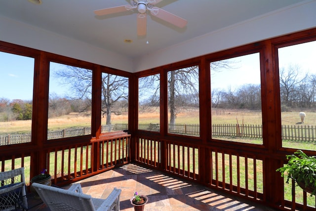 sunroom / solarium with a rural view and ceiling fan