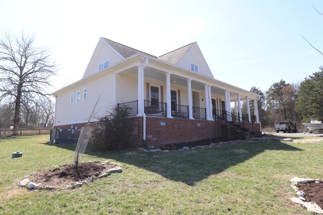 view of side of property with a porch and a yard