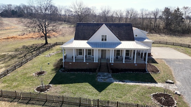 view of front of house with a porch, a front yard, and fence