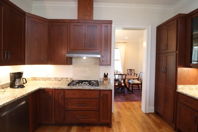 kitchen featuring under cabinet range hood, stainless steel gas cooktop, ornamental molding, light stone counters, and light wood-style flooring