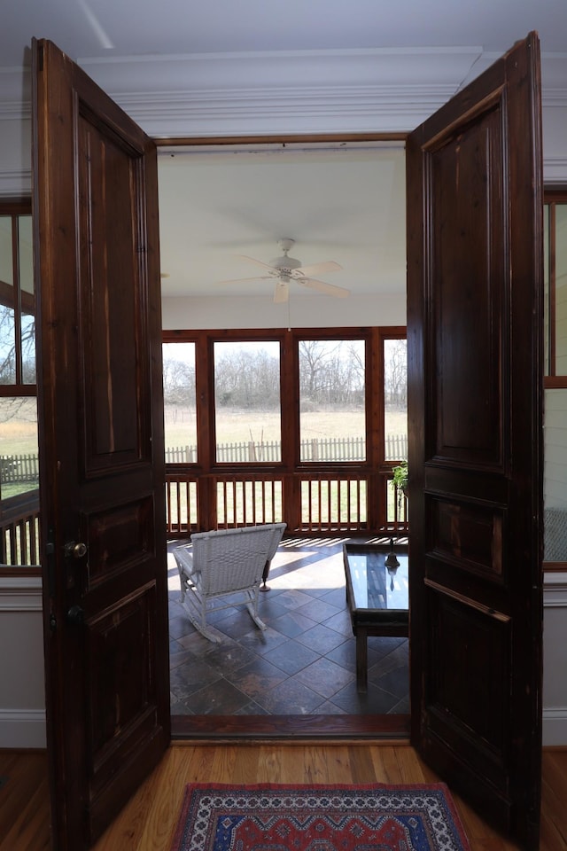 entryway featuring crown molding, a ceiling fan, and wood finished floors