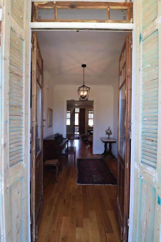 foyer entrance with ornamental molding and wood finished floors