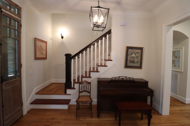 entrance foyer featuring stairs, a notable chandelier, and wood finished floors