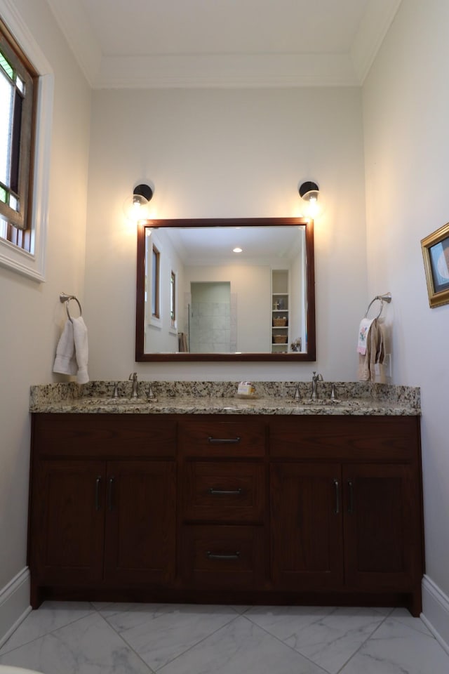 bathroom featuring a sink, double vanity, marble finish floor, and ornamental molding