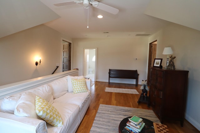 living room with visible vents, wood finished floors, baseboards, and ceiling fan