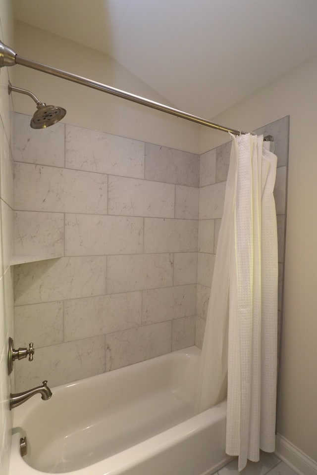 bathroom with baseboards and shower / bath combo with shower curtain