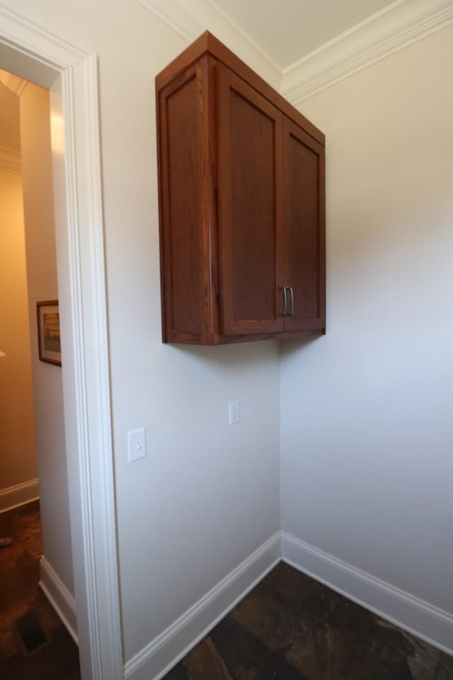 clothes washing area featuring visible vents, baseboards, and ornamental molding