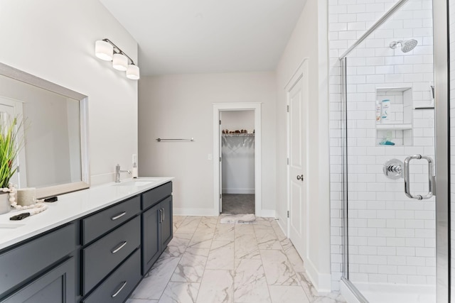 full bathroom featuring marble finish floor, a shower stall, baseboards, and vanity