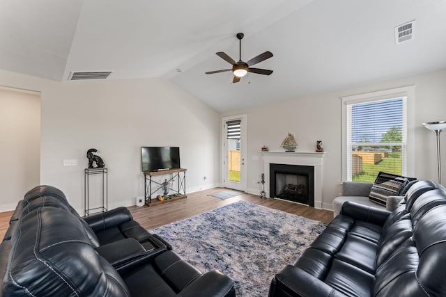 living area with lofted ceiling, wood finished floors, and visible vents