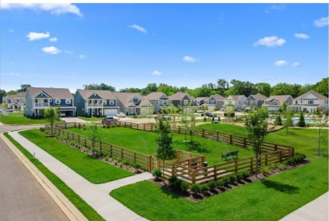 surrounding community with a yard, fence, and a residential view