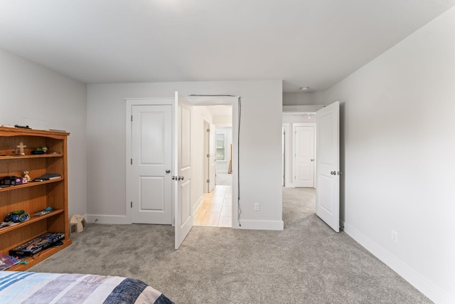 unfurnished bedroom with light carpet and baseboards