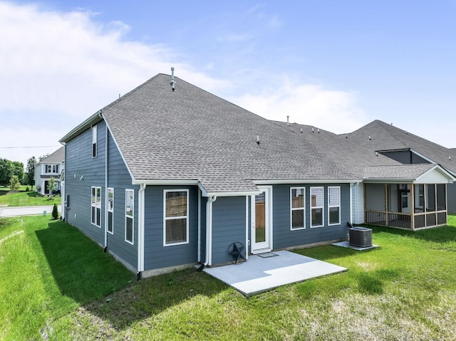 back of house featuring a patio, a yard, a shingled roof, and a sunroom