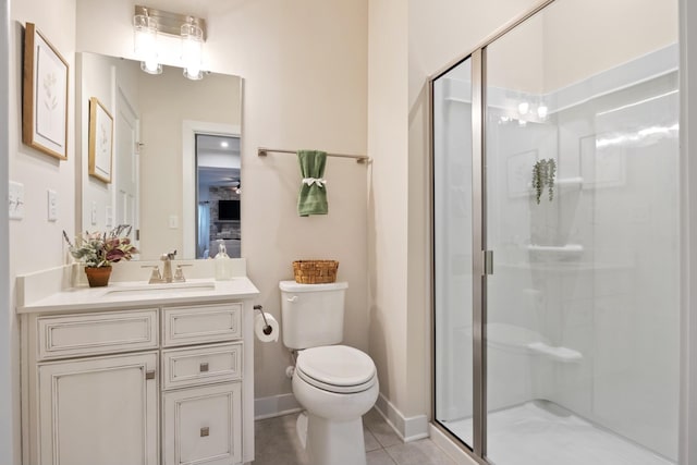 bathroom with a stall shower, vanity, toilet, and tile patterned floors