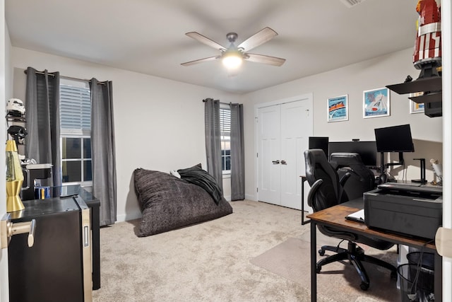 home office featuring carpet floors, baseboards, and a ceiling fan