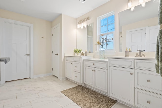 full bathroom featuring double vanity, marble finish floor, baseboards, and a sink