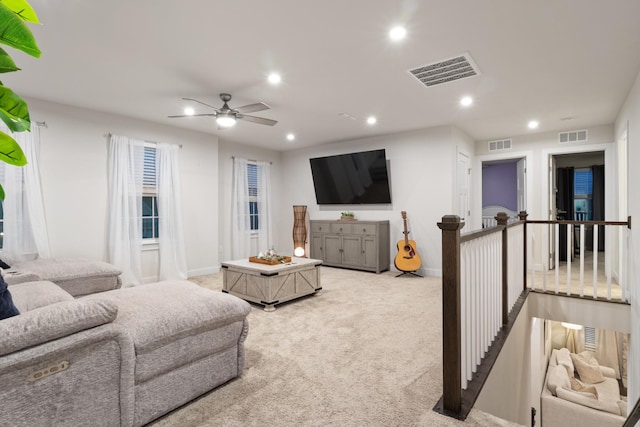 living area featuring recessed lighting, visible vents, and light carpet