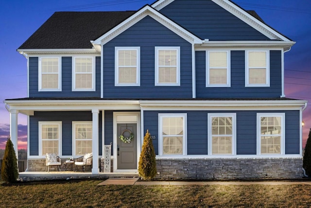 view of front of home featuring a porch and stone siding