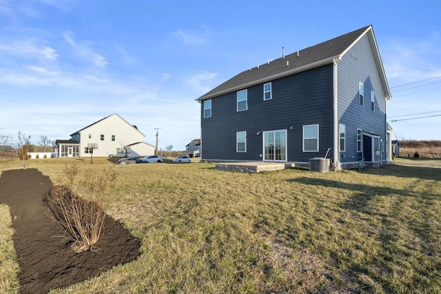 rear view of property with central air condition unit, a lawn, and a patio