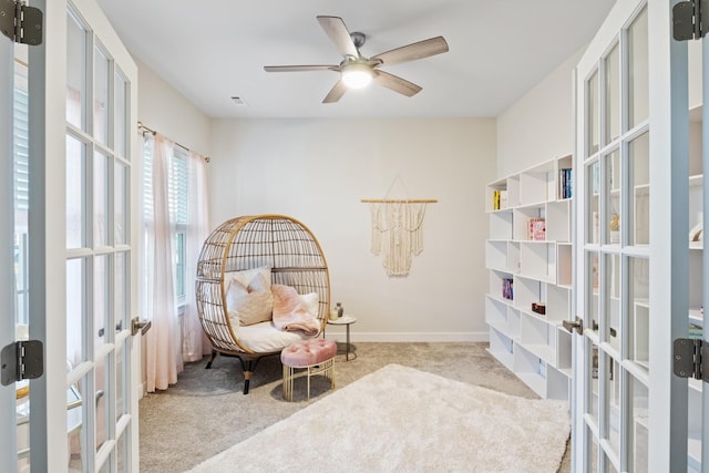 sitting room featuring carpet floors, french doors, baseboards, and a ceiling fan