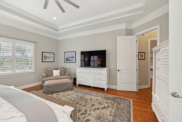 bedroom with crown molding, baseboards, a raised ceiling, and wood finished floors